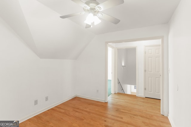 additional living space featuring light wood-style flooring, baseboards, lofted ceiling, and ceiling fan