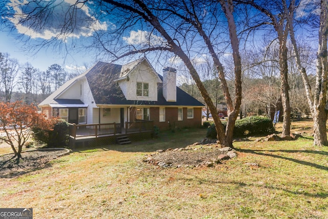 view of front facade featuring a wooden deck, a chimney, and a front lawn