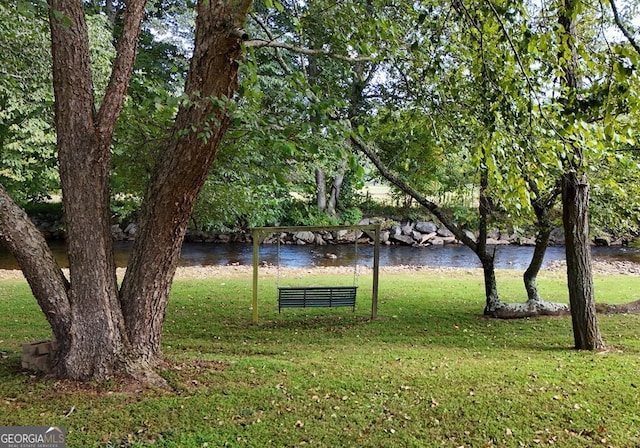 view of home's community featuring a lawn and a water view