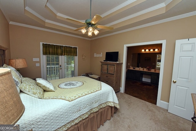 bedroom featuring a tray ceiling, ornamental molding, ensuite bathroom, access to outside, and carpet flooring