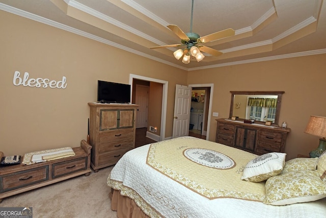 carpeted bedroom with a tray ceiling, ceiling fan, and ornamental molding