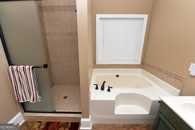 bathroom with vanity, a bath, and a stall shower