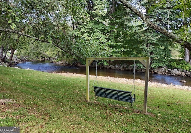 view of community featuring a lawn and a water view