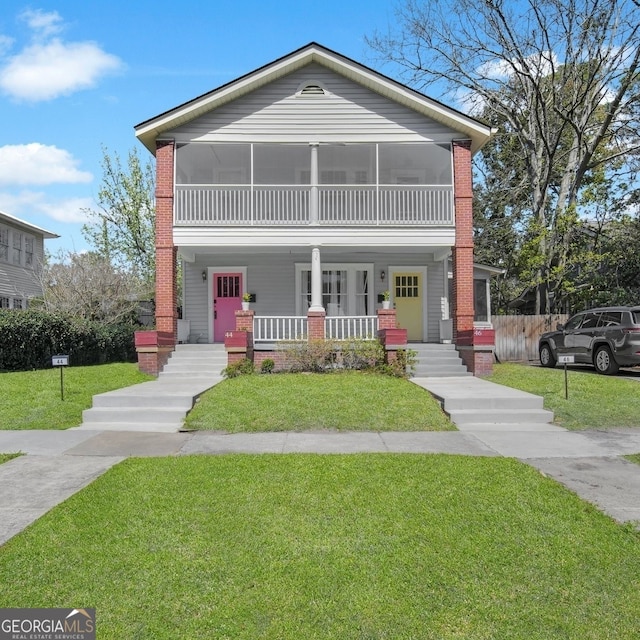 view of front of property with brick siding, covered porch, and a front yard