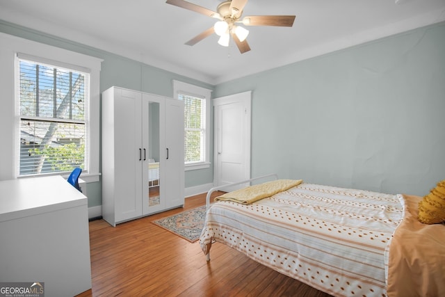 bedroom with baseboards, light wood-type flooring, and a ceiling fan