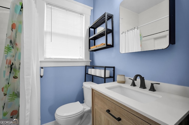 bathroom with curtained shower, toilet, and vanity