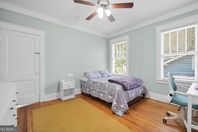 bedroom featuring light wood-style flooring, baseboards, and ceiling fan