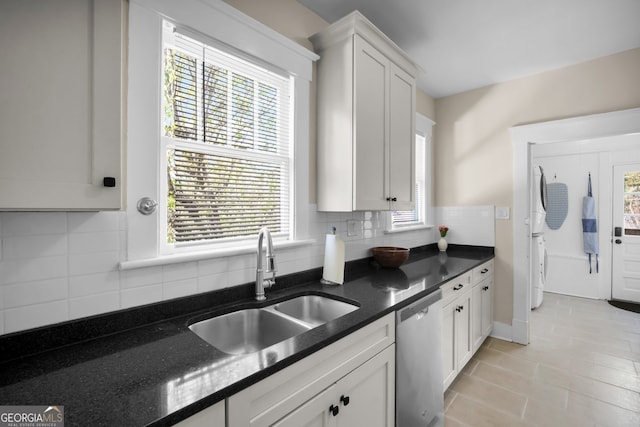 kitchen with dishwasher, dark stone counters, decorative backsplash, white cabinetry, and a sink