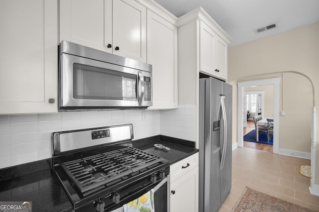 kitchen featuring visible vents, baseboards, decorative backsplash, appliances with stainless steel finishes, and white cabinetry