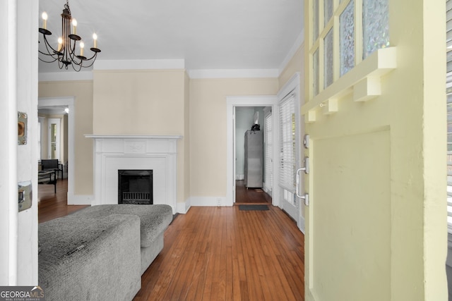 interior space featuring baseboards, an inviting chandelier, dark wood finished floors, and a fireplace