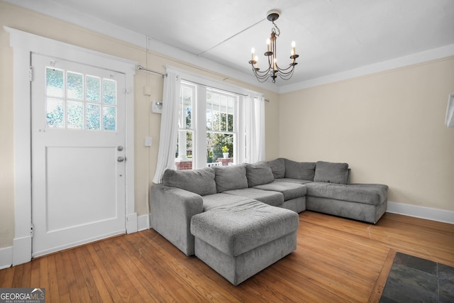 living area with baseboards, an inviting chandelier, and wood-type flooring