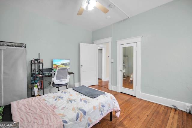 bedroom featuring wood finished floors, baseboards, and ceiling fan