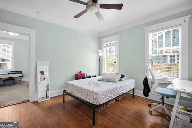 bedroom featuring a ceiling fan, baseboards, and wood-type flooring