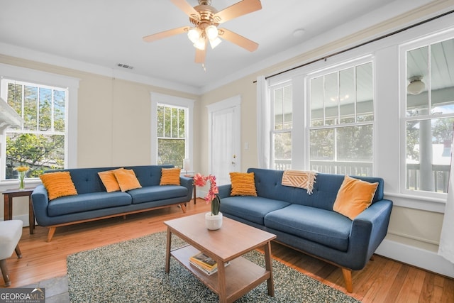 living room with visible vents, a ceiling fan, and hardwood / wood-style flooring