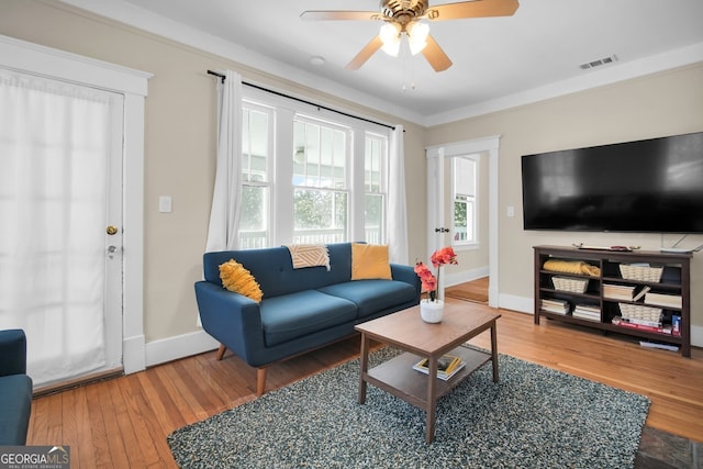 living area with visible vents, baseboards, ceiling fan, and hardwood / wood-style flooring