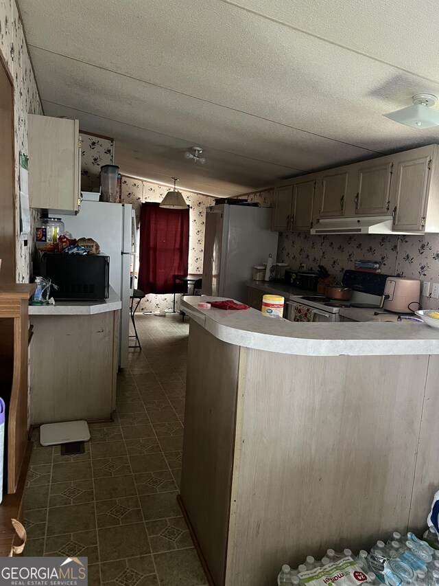 1357 Edgewood Ave, Douglas, GA 31533 - kitchen featuring light countertops, a peninsula, under cabinet range hood, electric stove, and freestanding refrigerator