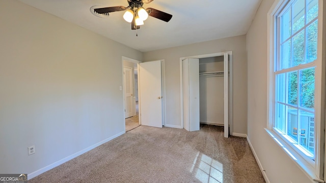 unfurnished bedroom with carpet flooring, baseboards, a closet, and ceiling fan