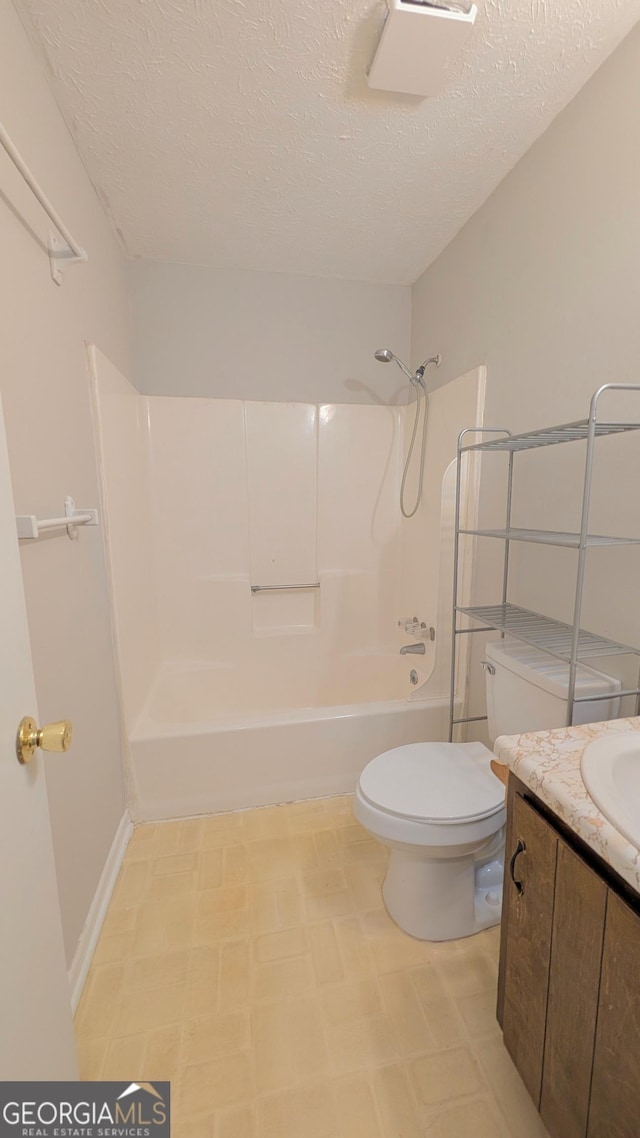 full bath with shower / washtub combination, a textured ceiling, toilet, and vanity