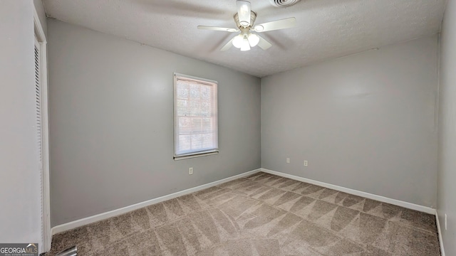 carpeted spare room with baseboards, a textured ceiling, and ceiling fan