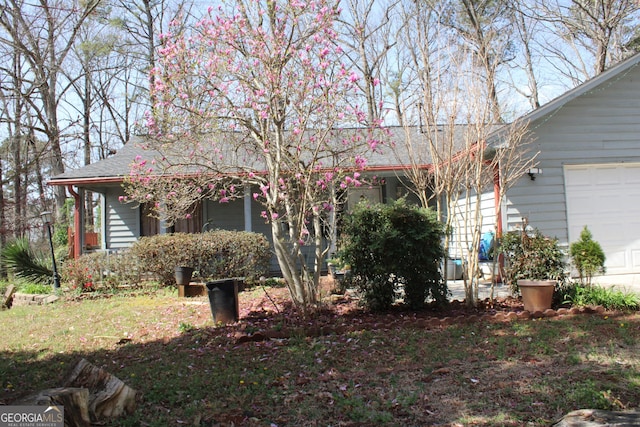 view of front of property featuring a garage and roof with shingles