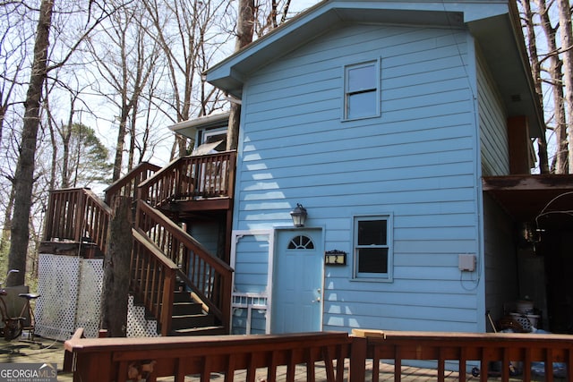 rear view of house featuring stairway and a wooden deck