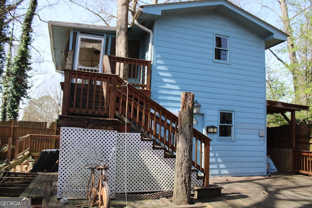 back of house with stairway, fence, and a wooden deck