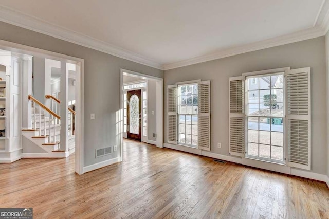 interior space featuring stairway, ornamental molding, baseboards, and wood finished floors