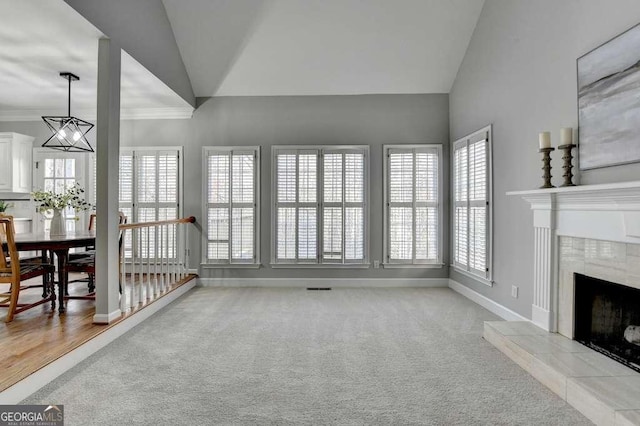 living room with a fireplace, baseboards, crown molding, and carpet