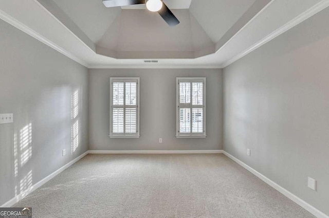 carpeted spare room featuring visible vents, ornamental molding, baseboards, a raised ceiling, and ceiling fan