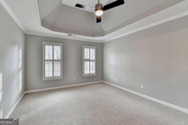 spare room with baseboards, visible vents, ornamental molding, a raised ceiling, and carpet flooring