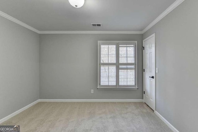 spare room featuring ornamental molding, carpet, visible vents, and baseboards