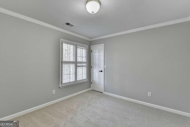 carpeted empty room featuring visible vents, crown molding, and baseboards