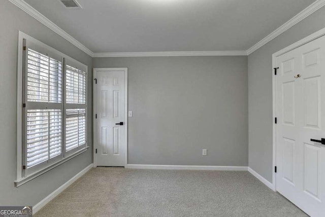 interior space featuring multiple windows, carpet, and ornamental molding