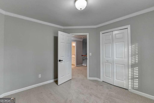 unfurnished bedroom with a closet, carpet flooring, baseboards, and ornamental molding