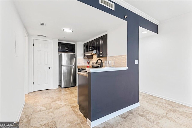 kitchen with visible vents, under cabinet range hood, appliances with stainless steel finishes, light countertops, and decorative backsplash