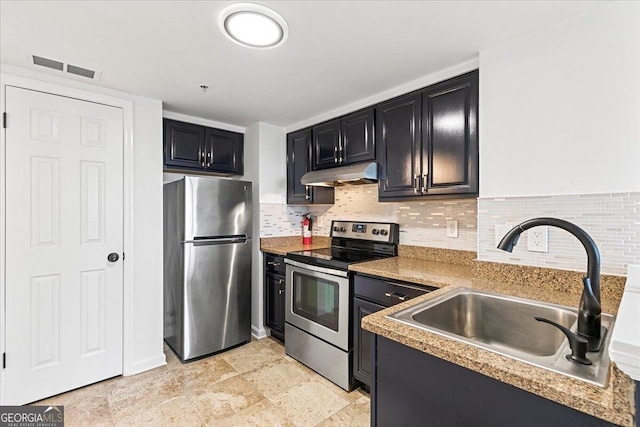 kitchen with under cabinet range hood, stainless steel appliances, dark cabinetry, and a sink