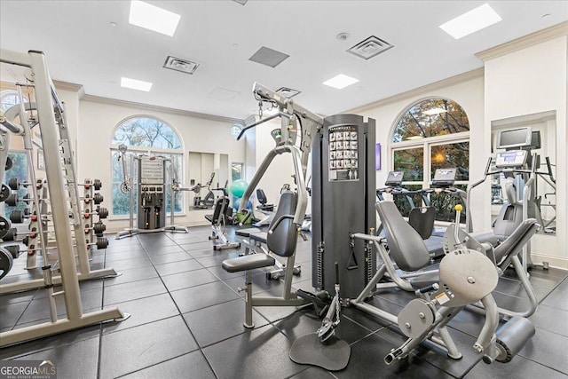 exercise room featuring visible vents, baseboards, and ornamental molding