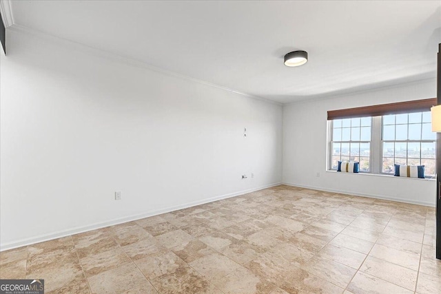 empty room featuring baseboards and crown molding