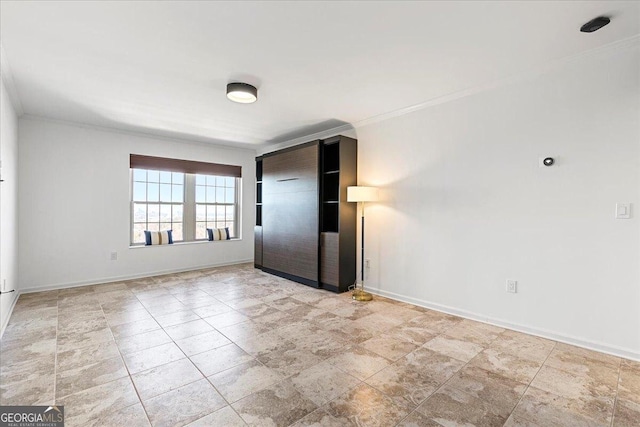 spare room with baseboards and crown molding