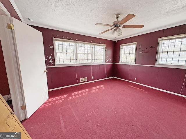 unfurnished room with visible vents, carpet, a ceiling fan, and a textured ceiling