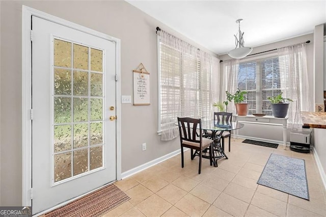 dining space with baseboards and light tile patterned flooring