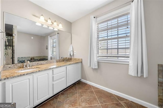 bathroom with double vanity, tile patterned flooring, baseboards, and a sink