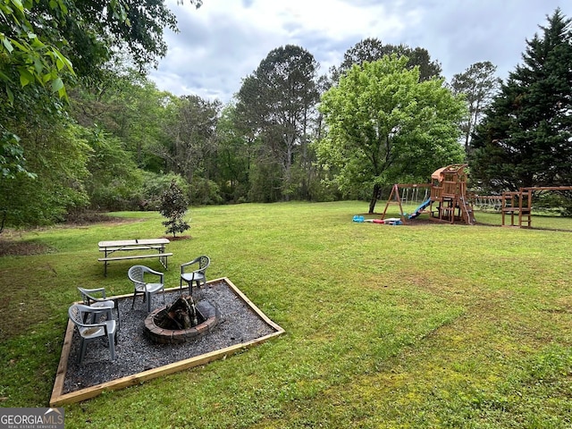 view of yard with a playground and an outdoor fire pit