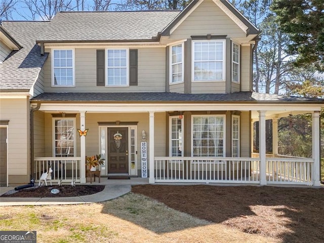 view of front of property with a shingled roof and covered porch