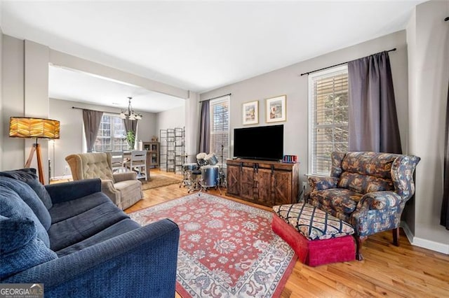 living area featuring an inviting chandelier and wood finished floors