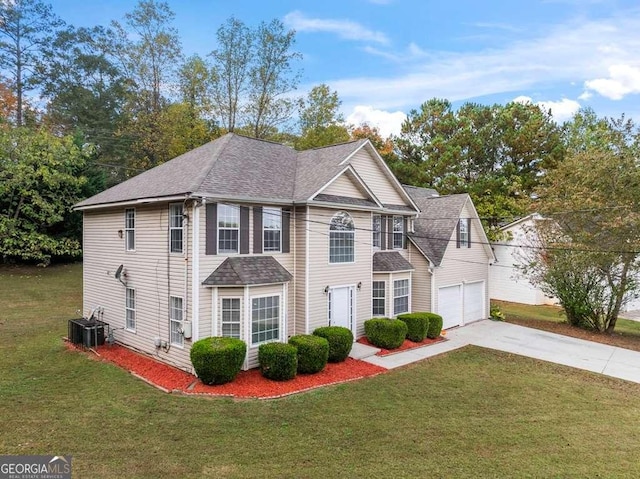 colonial home with a garage, concrete driveway, a front lawn, and roof with shingles