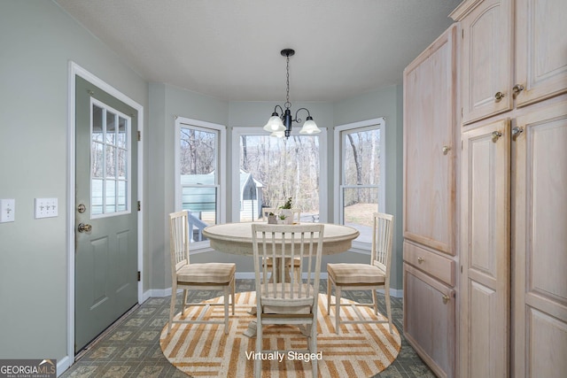 dining space with a notable chandelier and baseboards