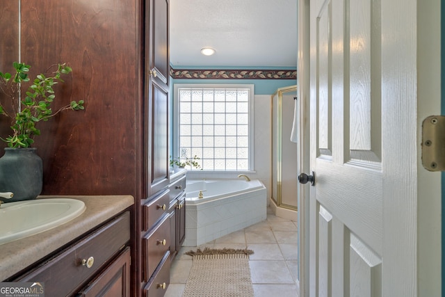 bathroom featuring tile patterned flooring, a bath, vanity, and a stall shower