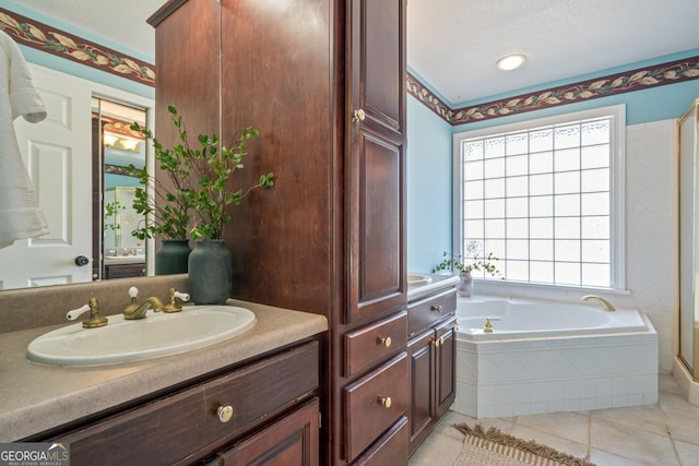 full bathroom with a garden tub, vanity, and tile patterned flooring