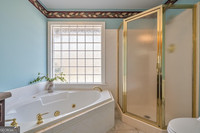 bathroom with tile patterned floors, toilet, a jetted tub, and a shower stall